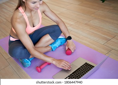 Fit Sporty Young Woman Sit On Mat Using Laptop Search Online Fitness Tutorials Virtual Yoga Tv Fitness Class At Home Gym. Active Girl Doing Remote Workout Exercises Training Video Program On Computer.