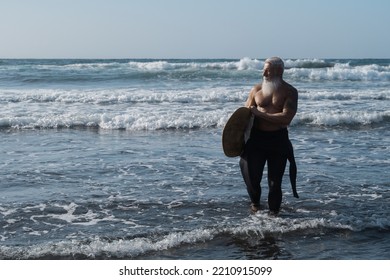 Fit Surfer Senior Man Holding Surf Board During Sport Water Training - Focus On Face.