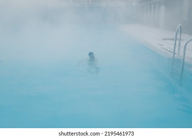 Fit Swimmer Male Training Swim In Open Winter Swimming Pool With Fog. Geothermal Outdoor Spa Health Concept.