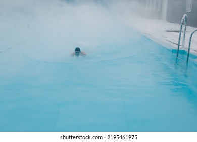 Fit Swimmer Male Training Swim In Open Winter Swimming Pool With Fog. Geothermal Outdoor Spa Health Concept.