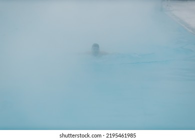 Fit Swimmer Male Training Swim In Open Winter Swimming Pool With Fog. Geothermal Outdoor Spa Health Concept.