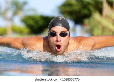 Fit swimmer sport athlete man training butterfly stroke in swimming pool. Professional male triathlete exercising for triathlon ironman swim.