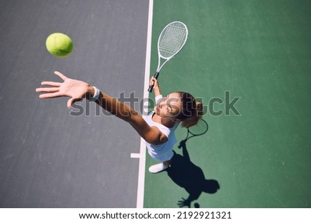 Fit tennis player, sport and serving during training, workout and exercise or match, game and competition from above. Sporty, active and healthy woman throwing a ball and practicing serve with