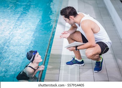 Fit trainer talking to swimmer in leisure center - Powered by Shutterstock