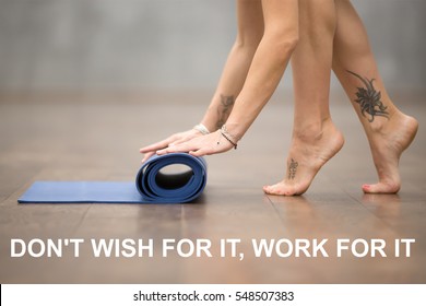 Fit woman with beautiful tattoo meaning "Wild kitty"  folding blue yoga or fitness mat. Motivation quote with motivational text "Do not wish for it, work for it". Healthy lifestyle concept