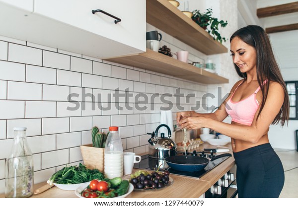 Fit woman cracking egg\
into frying pan
