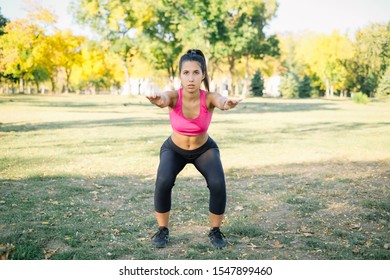 Fit Woman Demonstrating A Proper Squat Exercise