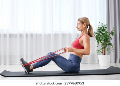 Fit woman doing exercise with fitness elastic band on mat at home - Powered by Shutterstock