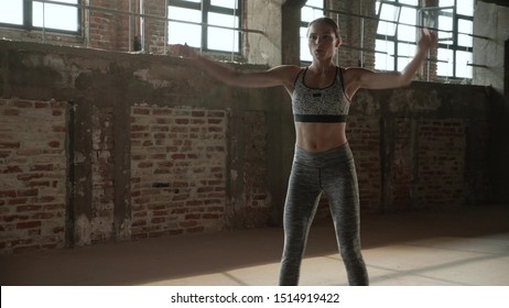 Fit Woman Doing Jumping Jack Exercise At Fitness Gym. Young Athletic Girl Doing Cardio Jump Workout, Having High Intensity Interval Training At Sport Club Indoors