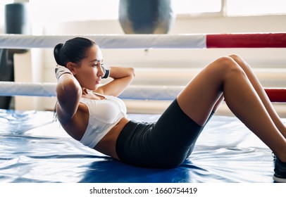 Fit woman doing sit up exercise on mat at boxing studio. Abs workout training for abdominal muscles. - Powered by Shutterstock