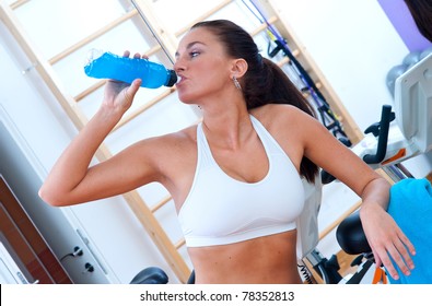 Fit Woman With Energy Drink Relaxing And Drinking In The Gym