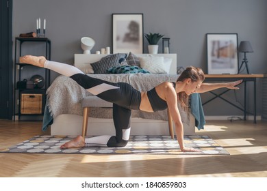 Fit Woman Excercising At Home Practising Yoga.