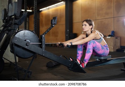 Fit Woman Is Exercising In A Rowing Exercise Machine. Healthy Lifestyle