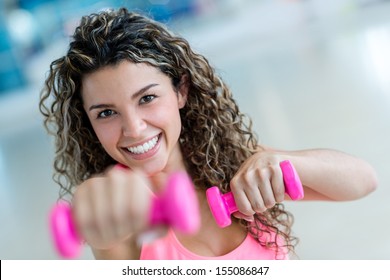 Fit woman at the gym lifting weights