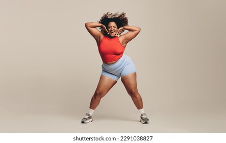 Fit woman having a blast as she moves her body in a dance workout session. Sporty woman putting her toned physique and athletic abilities on display as she lets loose with a fun physical activity.