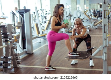 Fit woman and her trainer doing exercise. Personal trainer Coordinates woman training in gym - Powered by Shutterstock