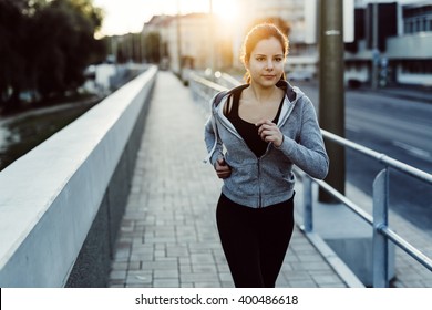 Fit Woman Jogging In City In Beautiful Sunset