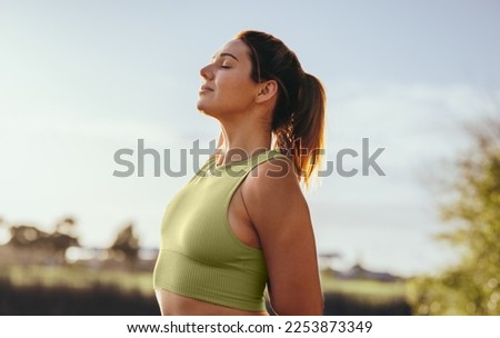 Fit woman practicing the standing cow face pose outdoors. Woman doing a warmup exercise during her morning workout. Sports woman practicing hatha yoga.