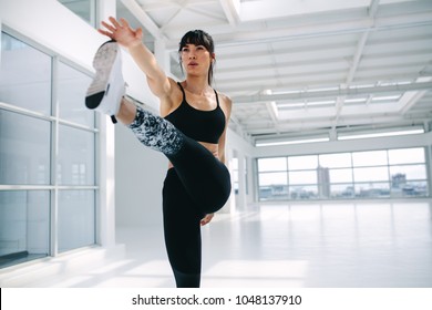 Fit Woman Practicing Yoga. Female Standing In Extended Hand To Big Toe Pose In Fitness Studio.