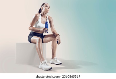 Fit woman relaxes and drinking water on seaside promenade after Workout training. - Powered by Shutterstock