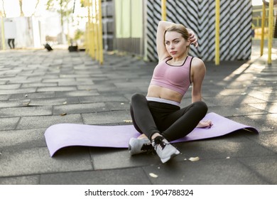 Fit Woman Resting On Yoga Mat At Outdoor Sports Ground