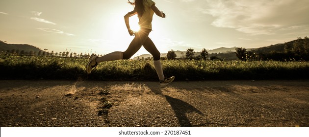 Fit woman running fast, training in bright sunshine