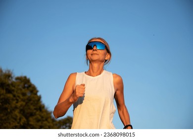 fit woman running at sunset - Powered by Shutterstock