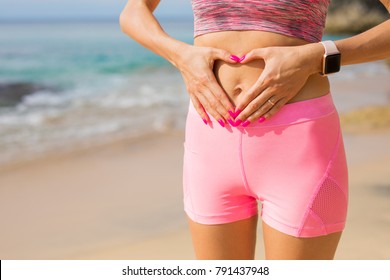 Fit Woman Showing Hands Heart Sign On Her Stomach