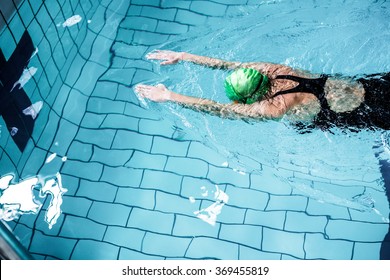 Fit woman swimming with swimming hat in swimming pool - Powered by Shutterstock