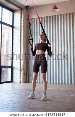 Fit woman training with fitness trx straps