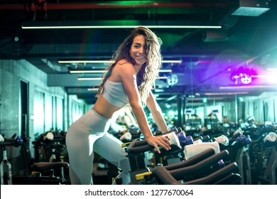 Fit woman working out on exercise bike at the gym