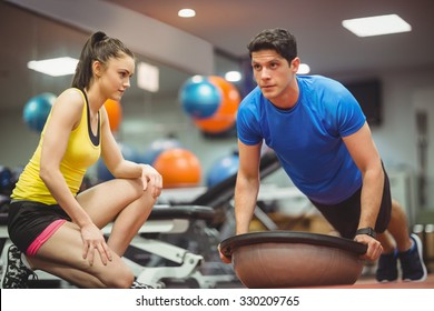 Fit woman working out with trainer at the gym - Powered by Shutterstock