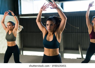 Fit Women With A Healthy Lifestyle Doing Jumping Jacks During High-intensity Interval Training. Pretty Women In A HIIT Class At The Gym