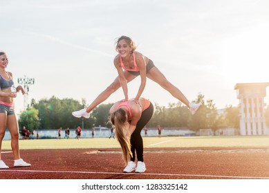 Fit Women At The Stadium Playing Leap Frog.