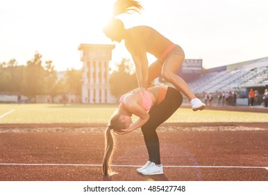 Fit Women At The Stadium Playing Leap Frog.