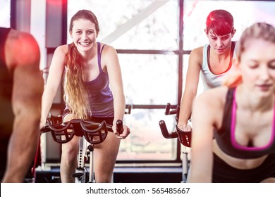 Fit women working out at spinning class in gym