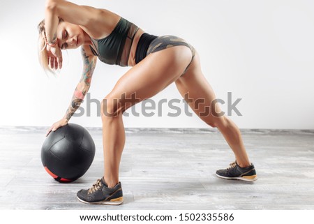 Fit young blonde woman rest after exercise with medicine ball in gym.