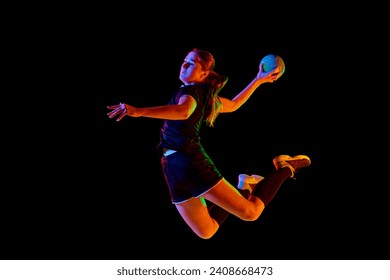 Fit, young, competitive female handball player demonstrating throwing techniques against black background in neon light. Concept of professional sport, movement, dynamic, workout, championship 2024 - Powered by Shutterstock