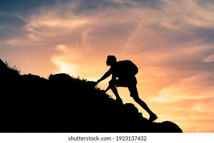 Fit young determined man climbing to top of mountain.  - Shutterstock ID 1923137432