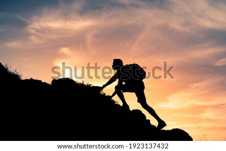 Fit young determined man climbing to top of mountain. 