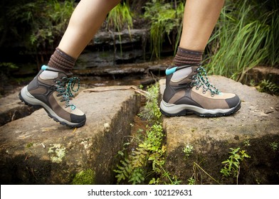 Fit Young Hiker Crosses Stone Steps In Hiking Boots