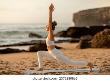 Fit young lady practicing yoga on ocean shore, standing in asana and doing breathing exercises, enjoy workout at sea beach, profile. Morning workout, fit, sports together, health care - Powered by Shutterstock