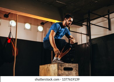 Fit Young Man Doing A Box Jump Exercise. Sports Man Doing A Box Squat At The Gym