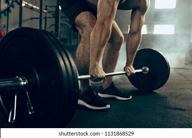 Fit young man lifting weight working out at a gym. Sport, fitness, weightlifting, bodybuilding, training, athlete, workout exercises concept