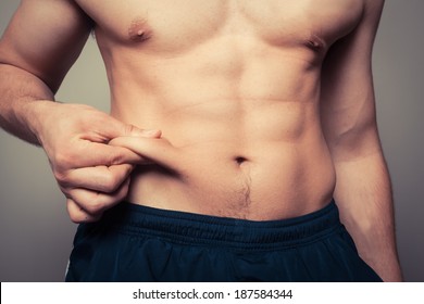 Fit Young Man Pinching The Fat On His Stomach