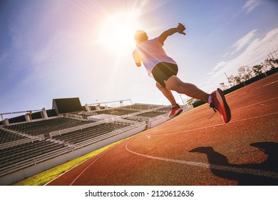 Fit young man running sprinting at the racetrack. Fit runner fitness runner during outdoor workout at racetrack. Start running concept. - Powered by Shutterstock