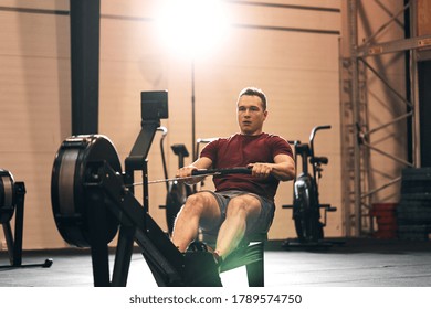 Fit young man in sportswear working out on a rowing machine during a gym exercise session - Shutterstock ID 1789574750