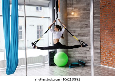 Fit Young Woman Does Stretching, Push Up And Pull Up On The Gymnastics Rings In Gym