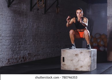 Fit Young Woman Doing Box Jump Exercise. Muscular Woman Doing Box Jumps At Gym