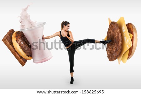 Fit young woman fighting off fast food